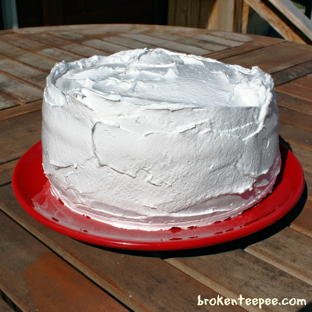 layer cake with Italian meringue frosting on red plate