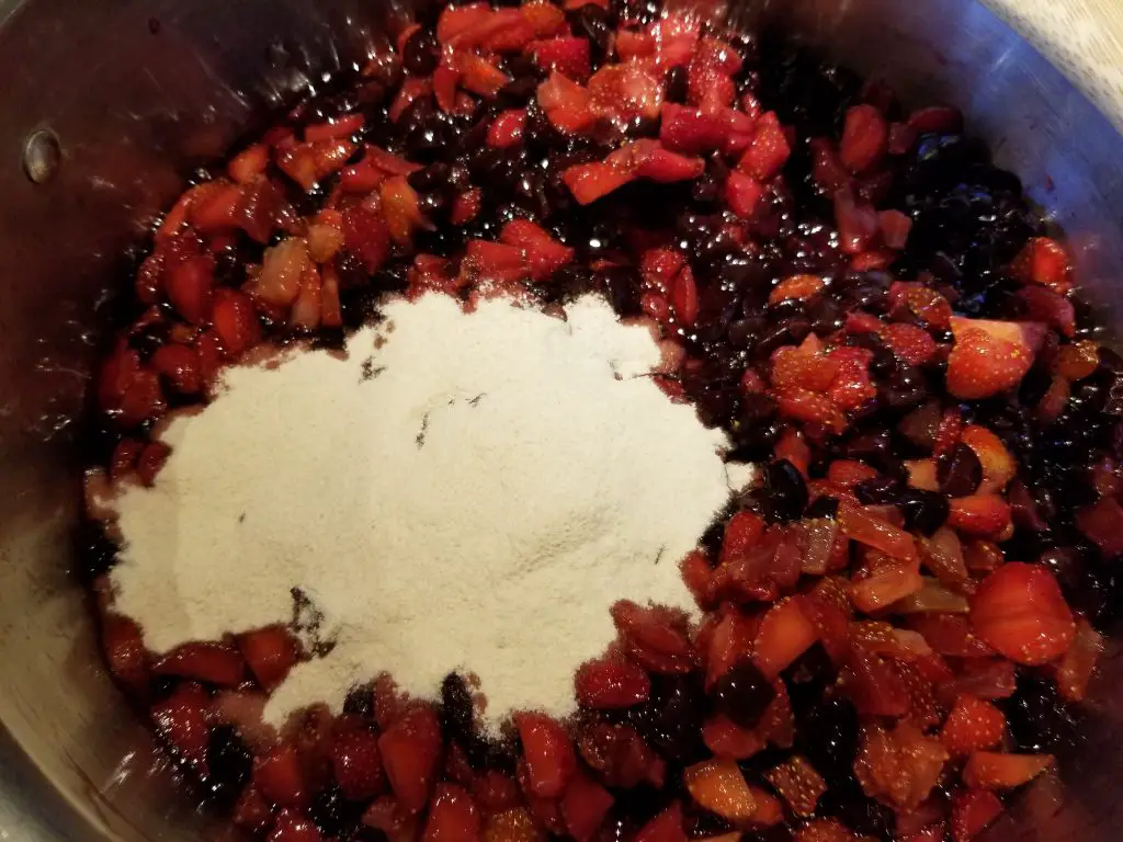 add sugar and pectin to fruit in pot