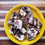 cheesecake brownies with fruit, cut, on a yellow plate
